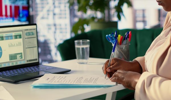 Business entrepreneur signing contracts and documents to approve the next activity for enterprise management and development. Female CEO working on legal paperwork, authorization. Camera A.